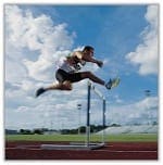 man jumping over hurdle